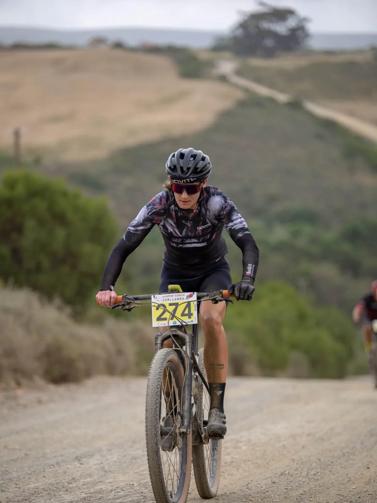 Christilee Jansen racing on a gravel climb